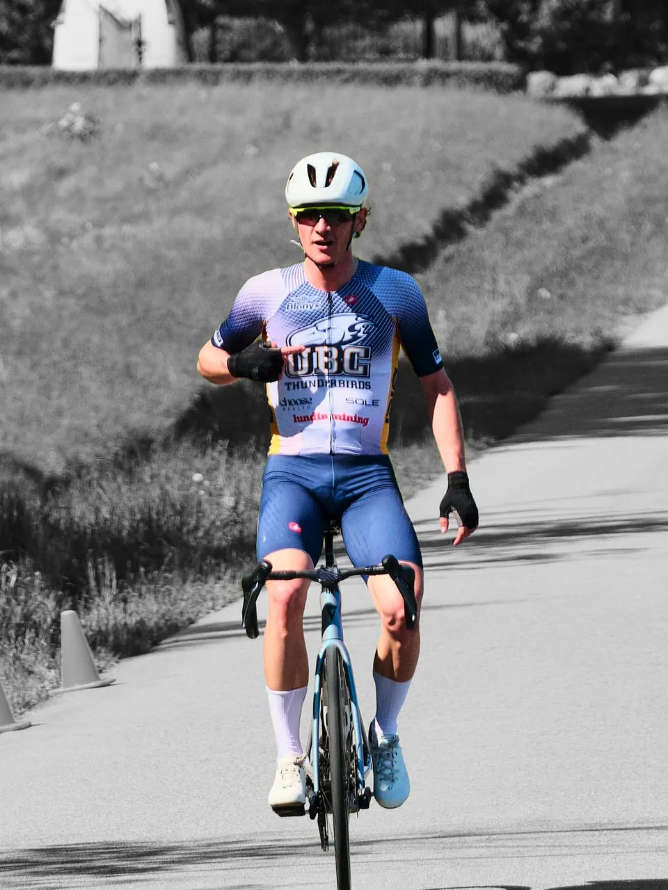 Manuel alone on the road at a finish, in colour against a black-and-white background